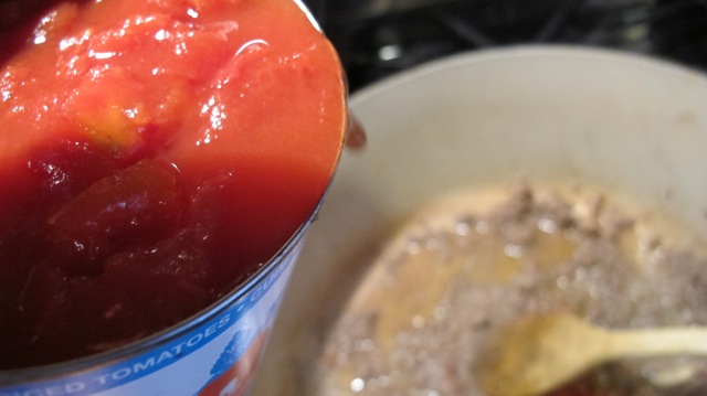 The can of diced tomatoes goes in. 