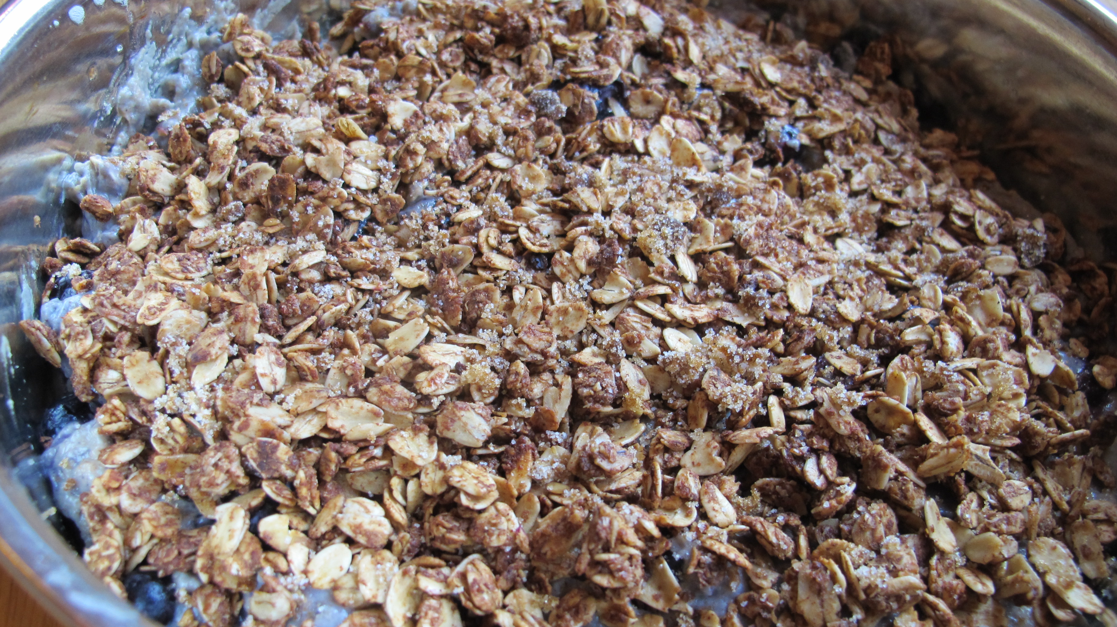 The granola, brown sugar, and honey is sprinkled over top the cake. 