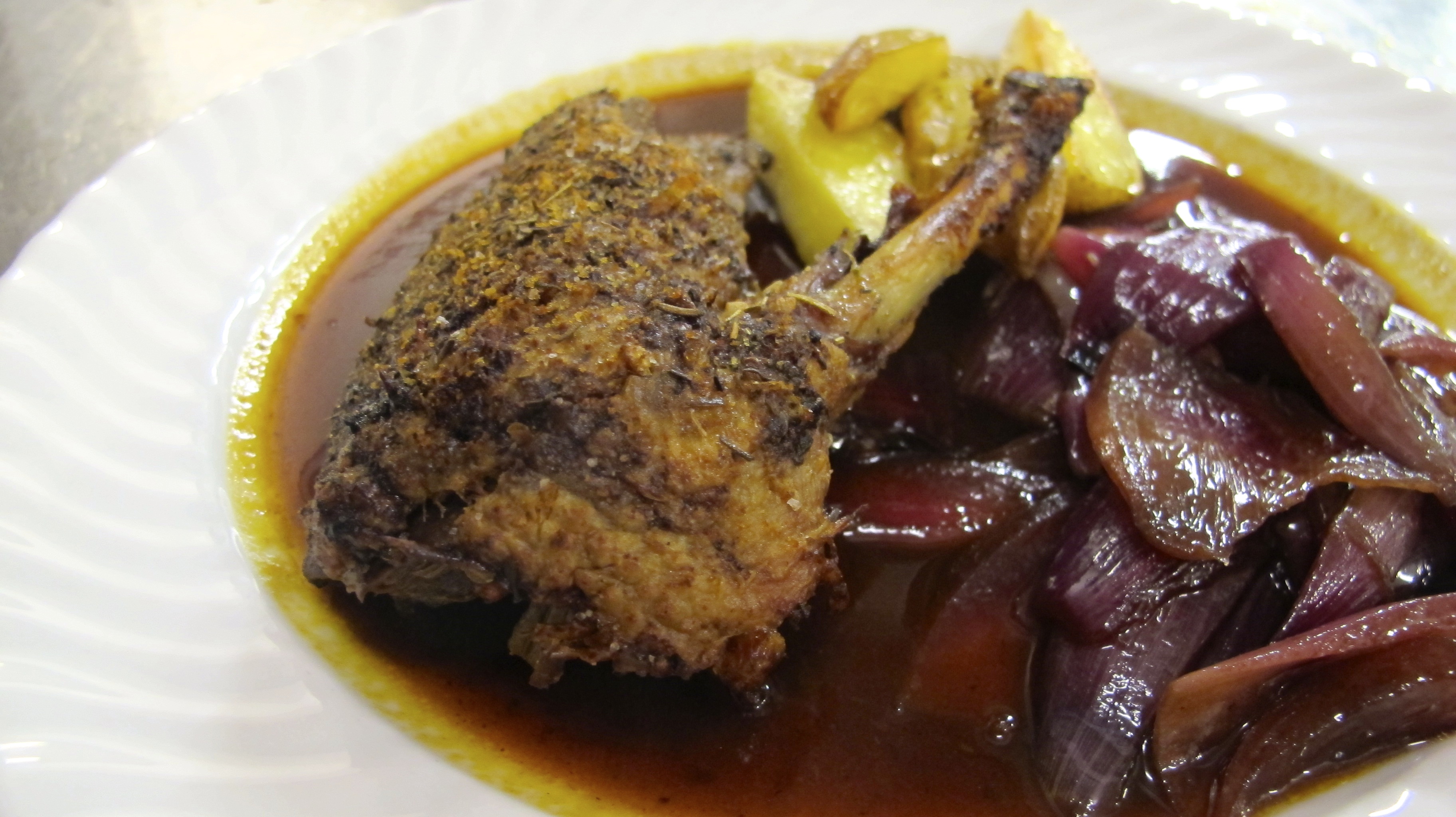 Herb-roasted duck with balsamic red onions and  potatoes. 