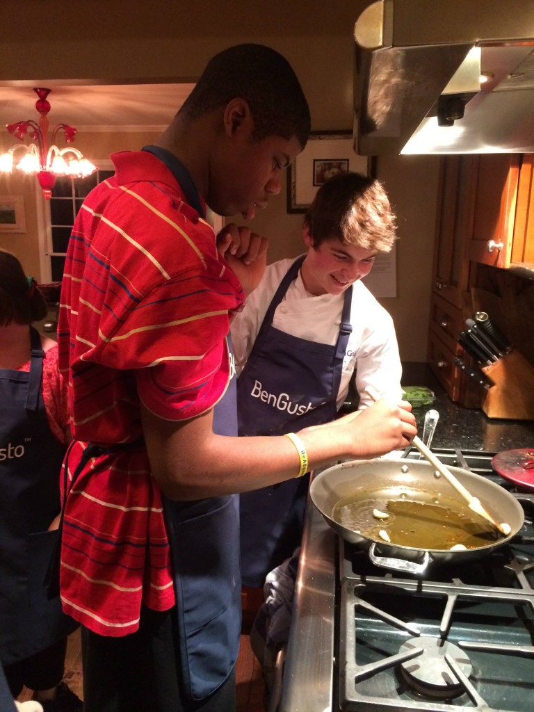 Marcus stirs the garlic in oil. 