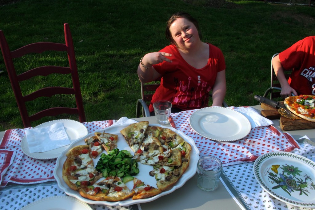 Beth poses with a tray of pizza she helped make. 
